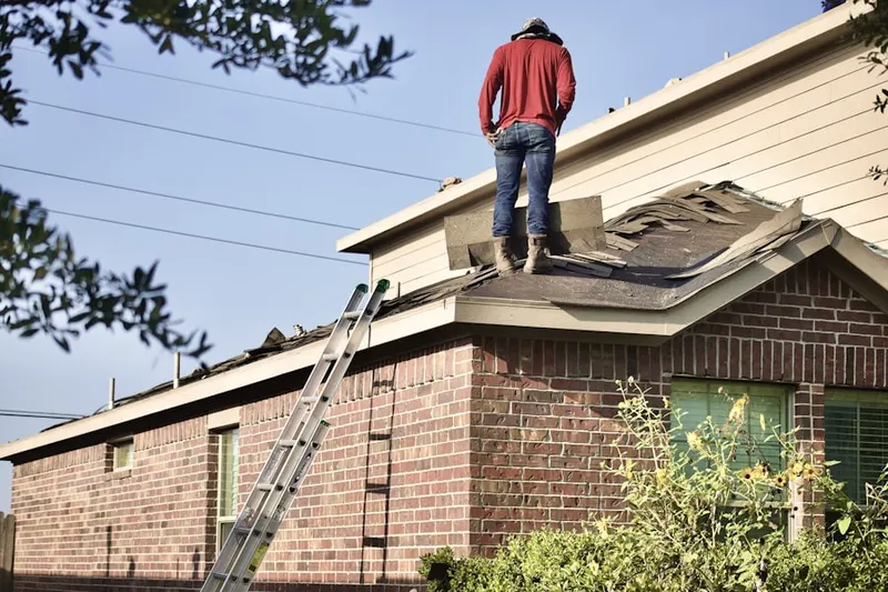 Professional roofer working on a residential roof in East Freedom